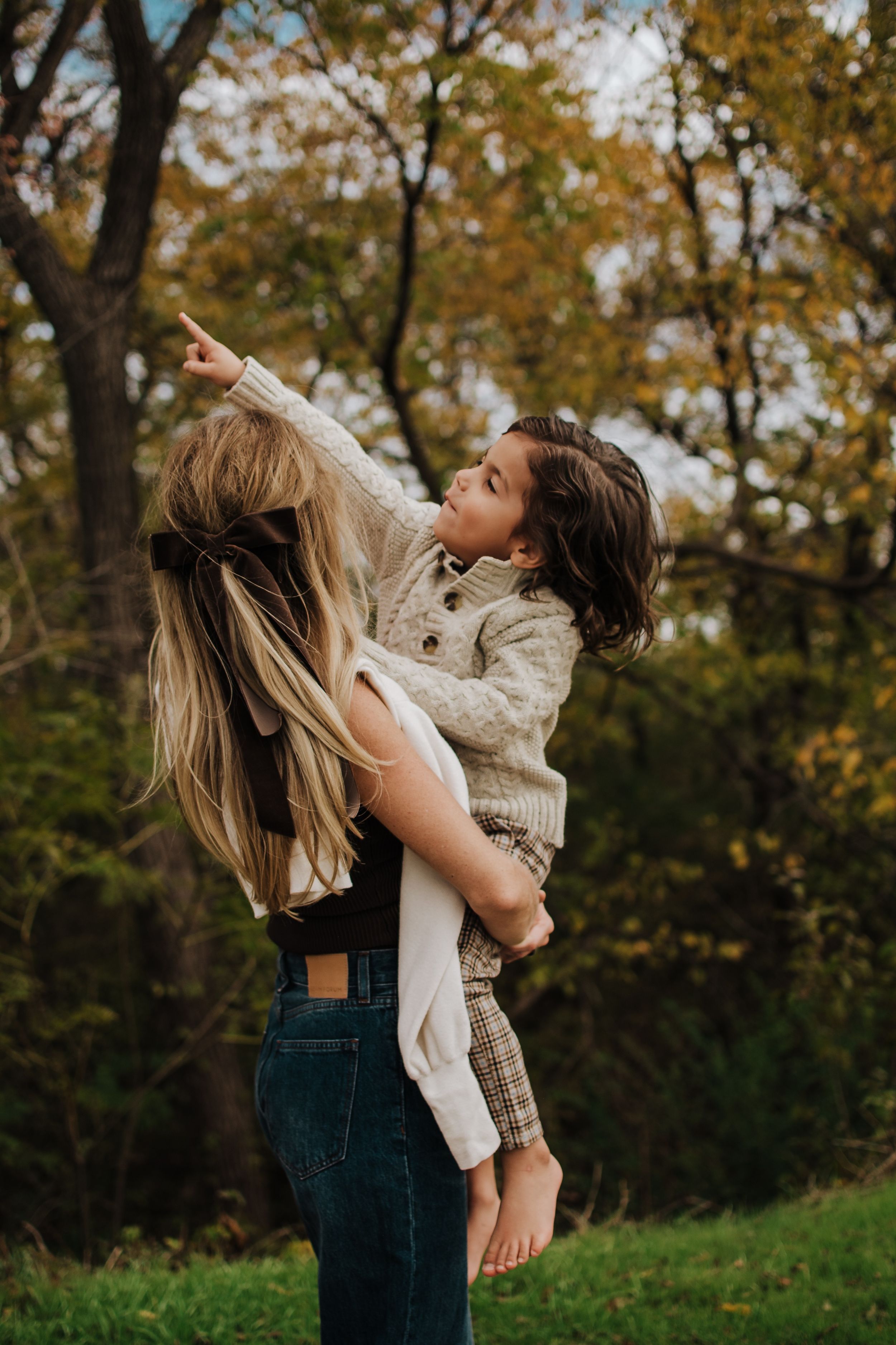 Candid moments of family laughter and play captured in a natural fall setting.