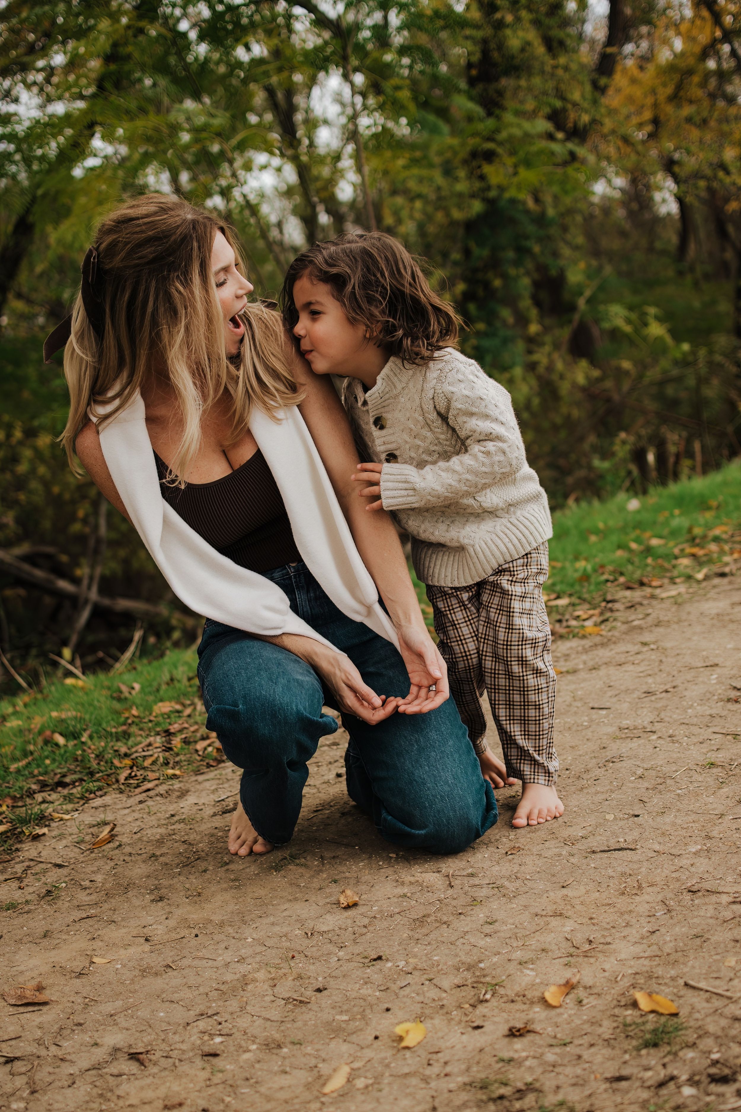 Intimate family bonding moment captured on a dirt path during autumn.
