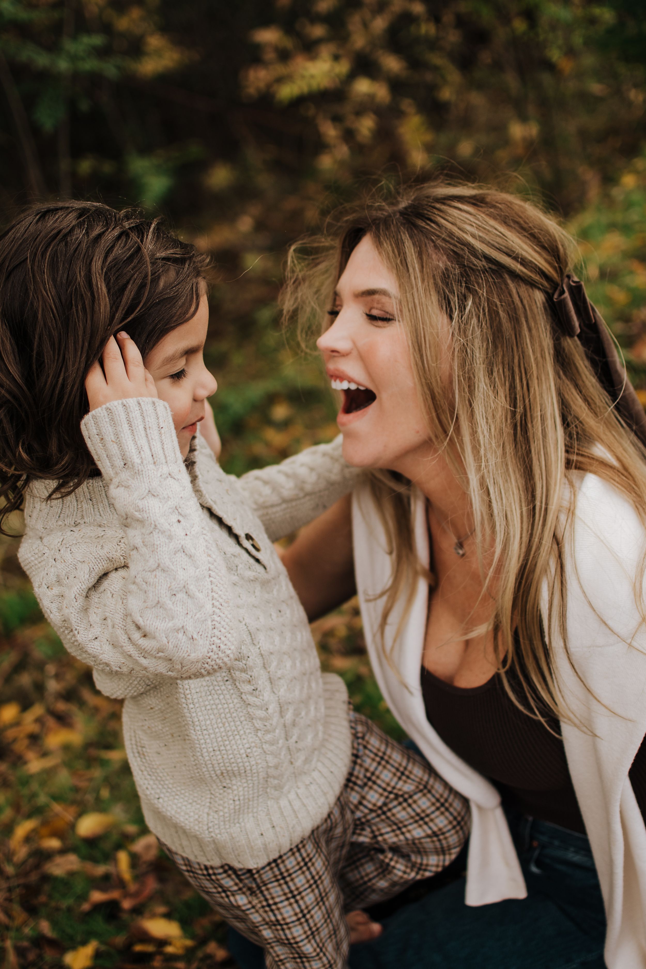 Sweet candid moments of family laughter and joy in an autumn park setting.