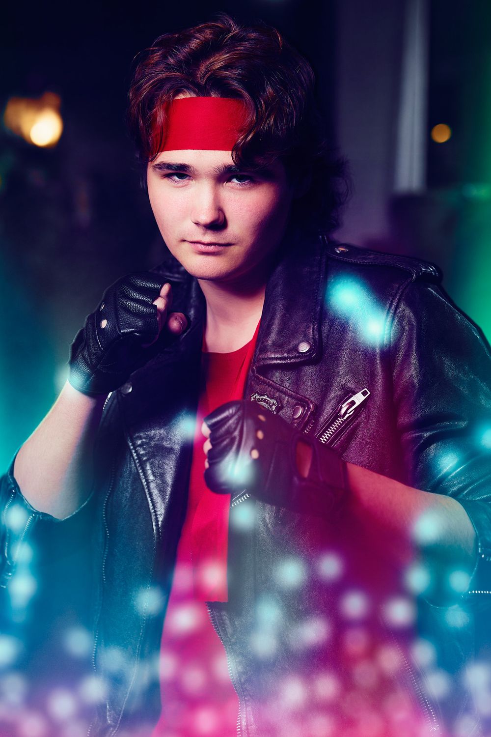 Dramatic portrait in cyberpunk style with leather jacket, red bandana and blue lighting effects.