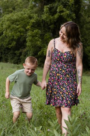 Candid moments of joy captured as two people play together in a lush green field.