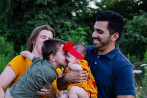 Candid family moments captured during an outdoor photoshoot in a natural setting.