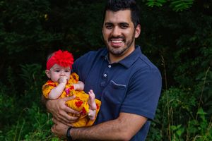 A casual outdoor portrait session with a family wearing coordinated colors against greenery.