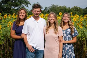 Family group photos taken in front of a vibrant sunflower field on a bright summer day.