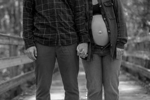 Black and white photos of a couple standing together on a wooden walkway.