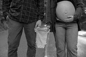 A close-up view of a couple's legs as they stand together outdoors.