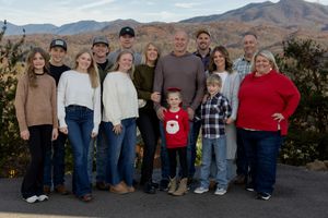 Extended family group photo session with mountain landscape backdrop.