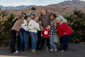 Family gathering outdoors with scenic mountain views in the background.