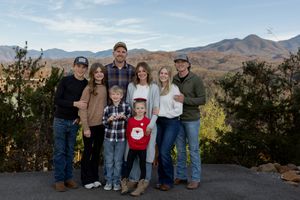 Large family group posed together with beautiful mountain vista behind them.