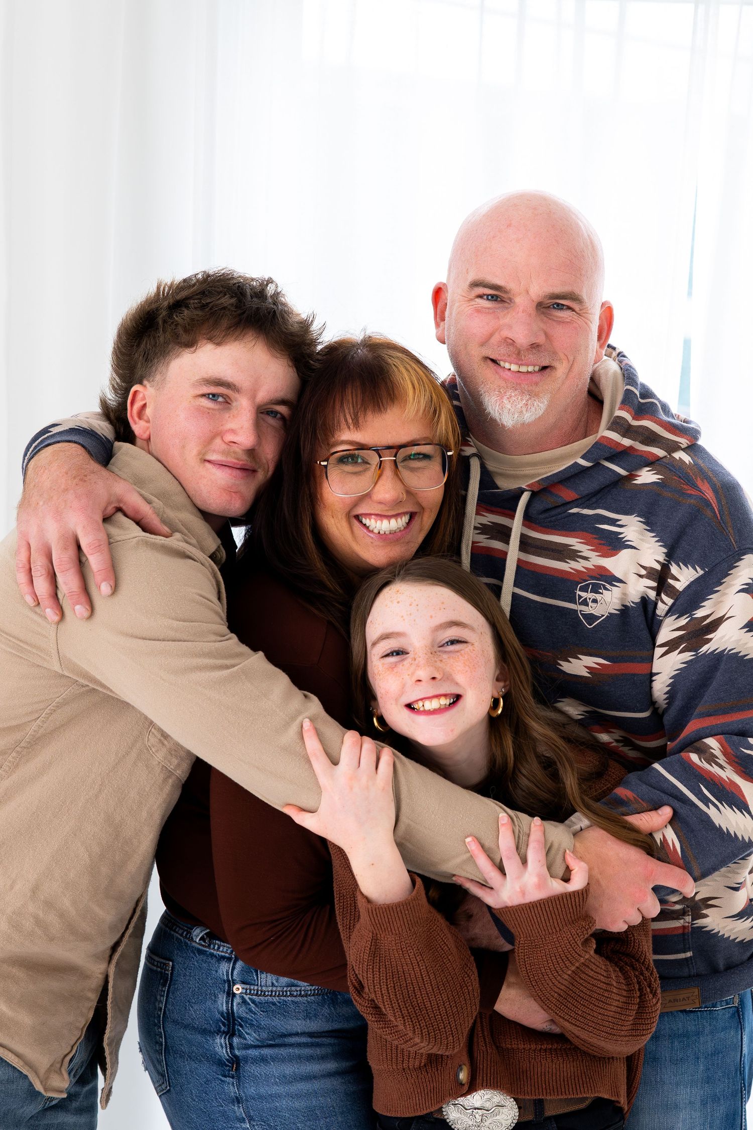 A playful series of four photos showing a family posing together in brown and denim outfits against a white background.