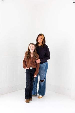 A series of four candid studio photos showing a person in a brown jacket and jeans sitting and posing against a white background.