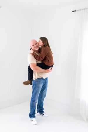 Three sequential photos show someone in jeans holding and spinning a small dog in a white studio setting.