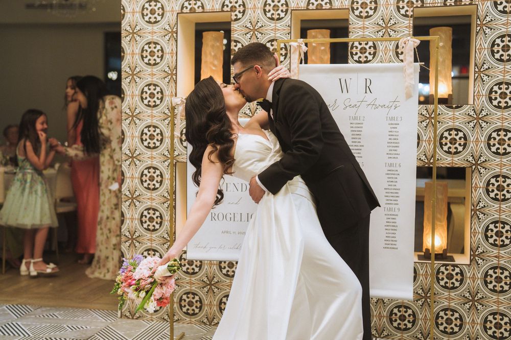 Wedding venue decorated with ornate wallpaper and seating charts displayed on easels.