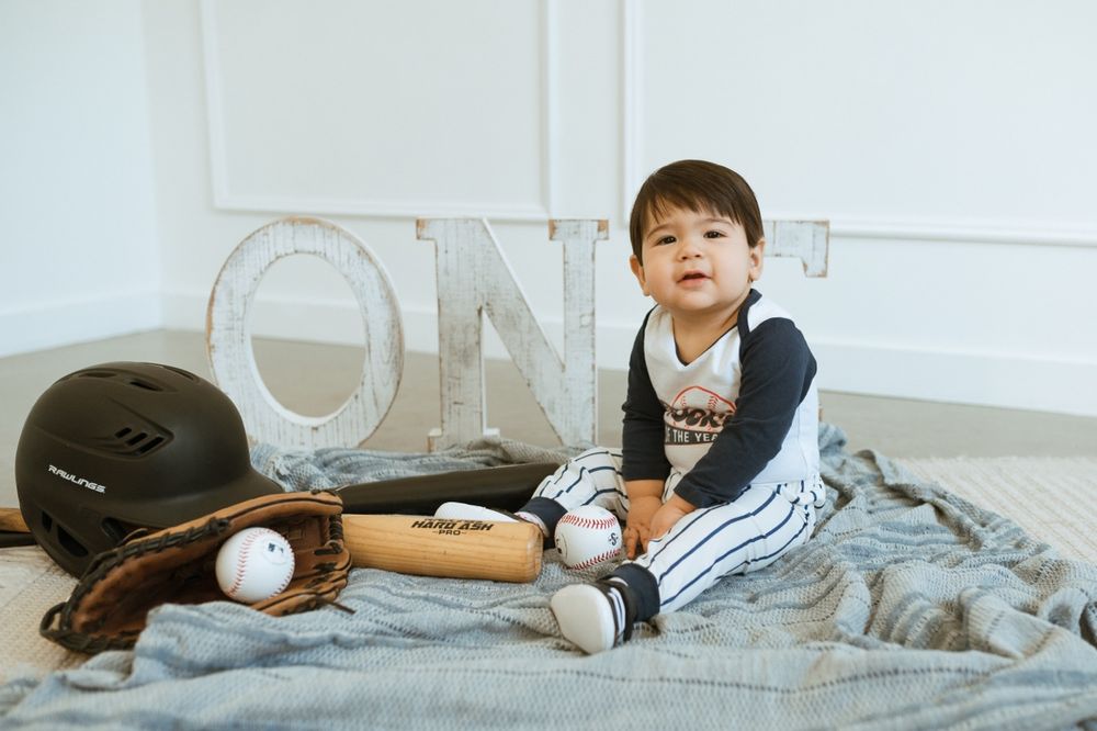 A baseball player lying down on a sofa in different casual lounging positions while wearing a cap.