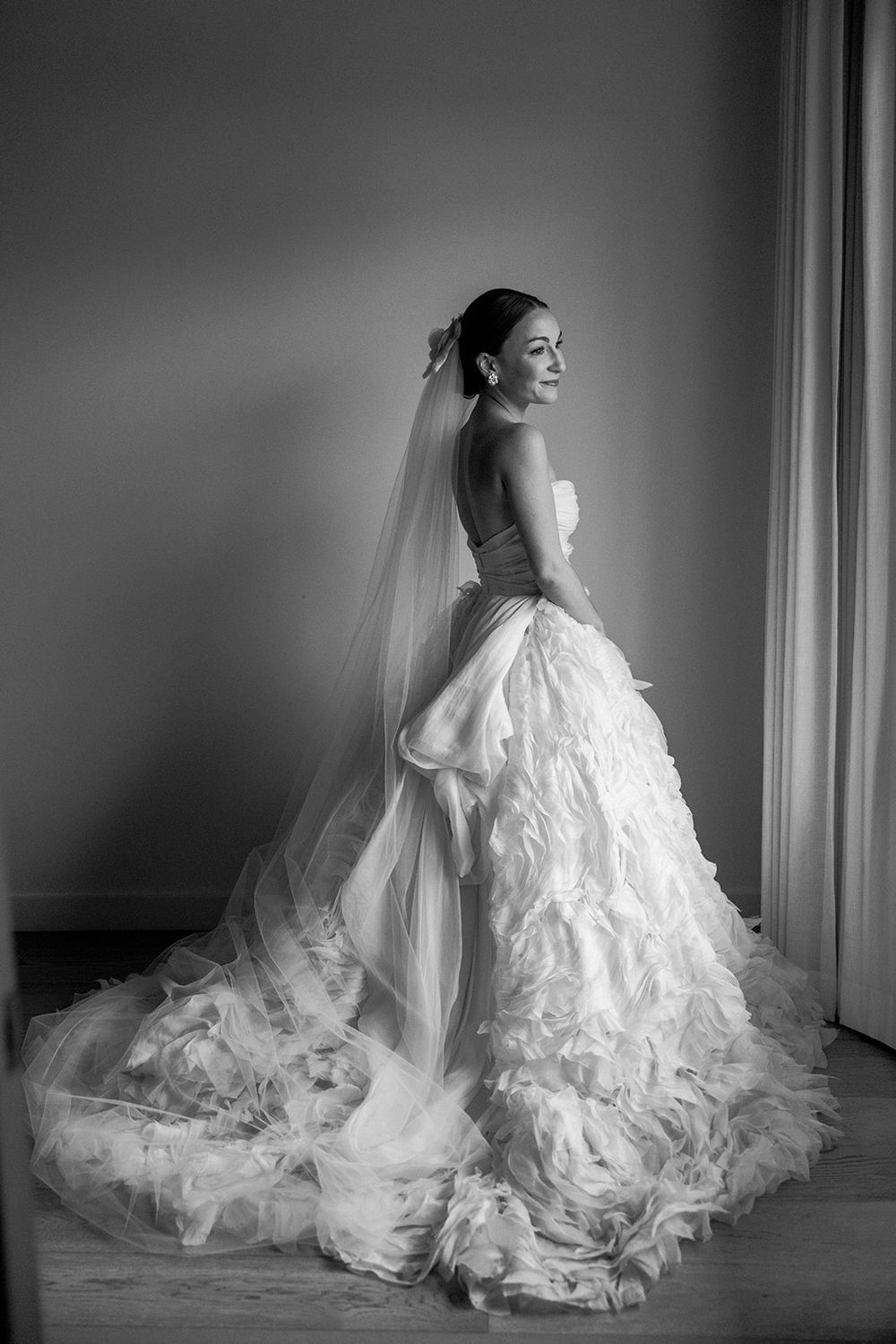 Dramatic black and white bridal portraits showing flowing white wedding gown with long train.