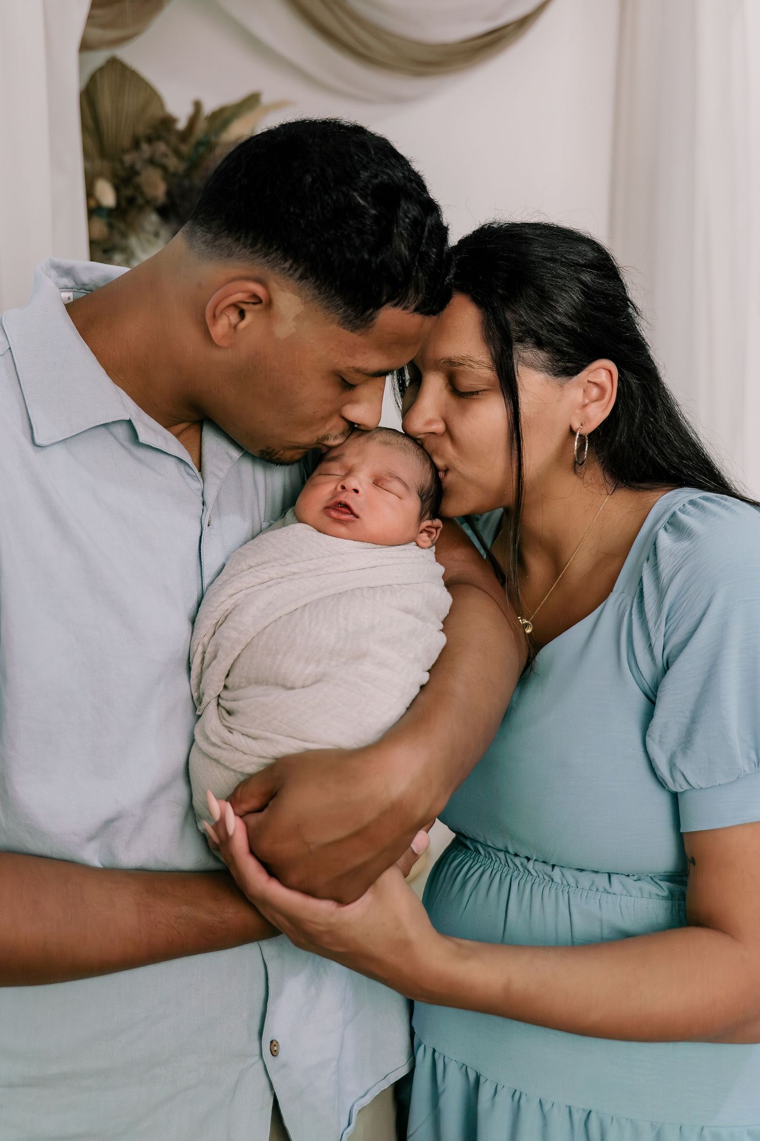 A series of intimate photos showing a couple in coordinating blue and white outfits embracing tenderly.