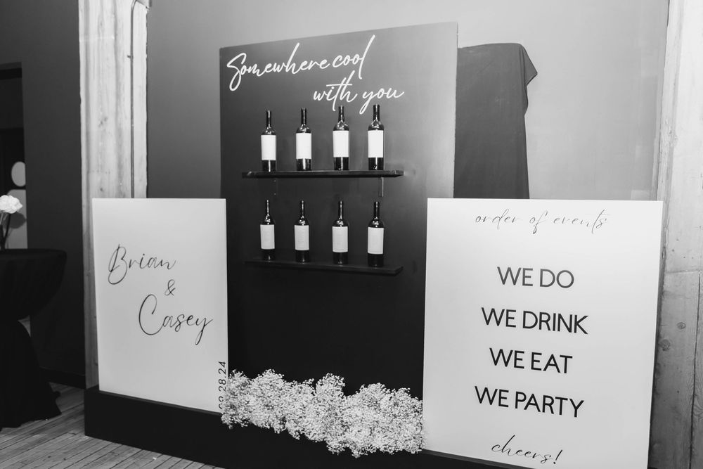 Black and white gallery wall displays a sequence of framed text quotes about drinking and partying.
