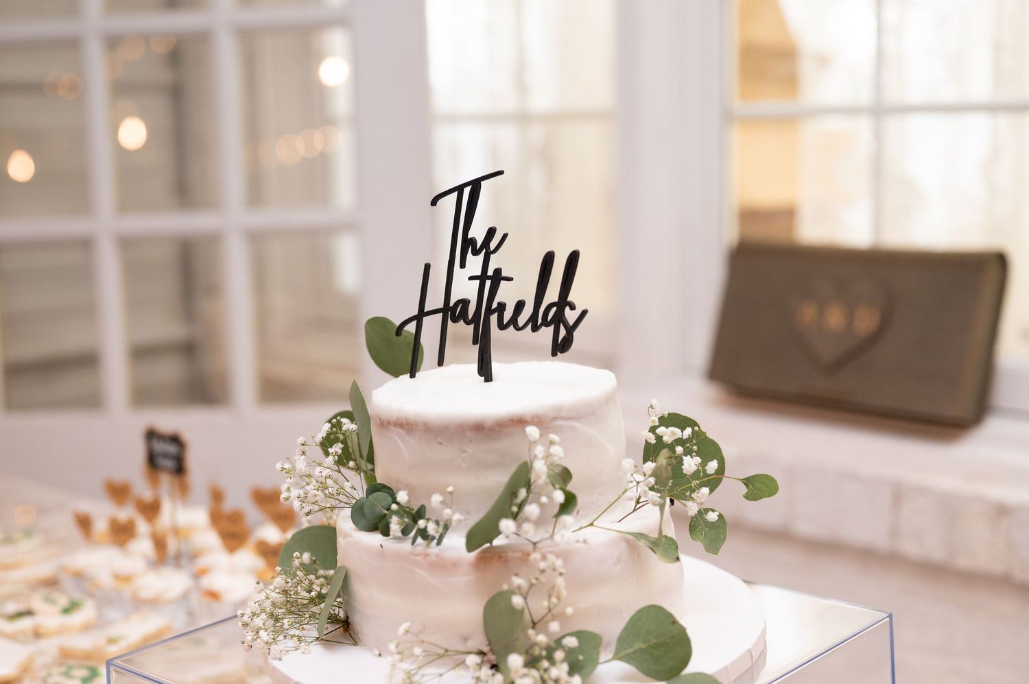 Wedding reception venue decorated with elegant table settings, eucalyptus garlands, and soft lighting for an intimate feel.
