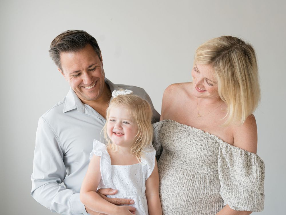Family of three laugh together while waiting for baby to arrive.