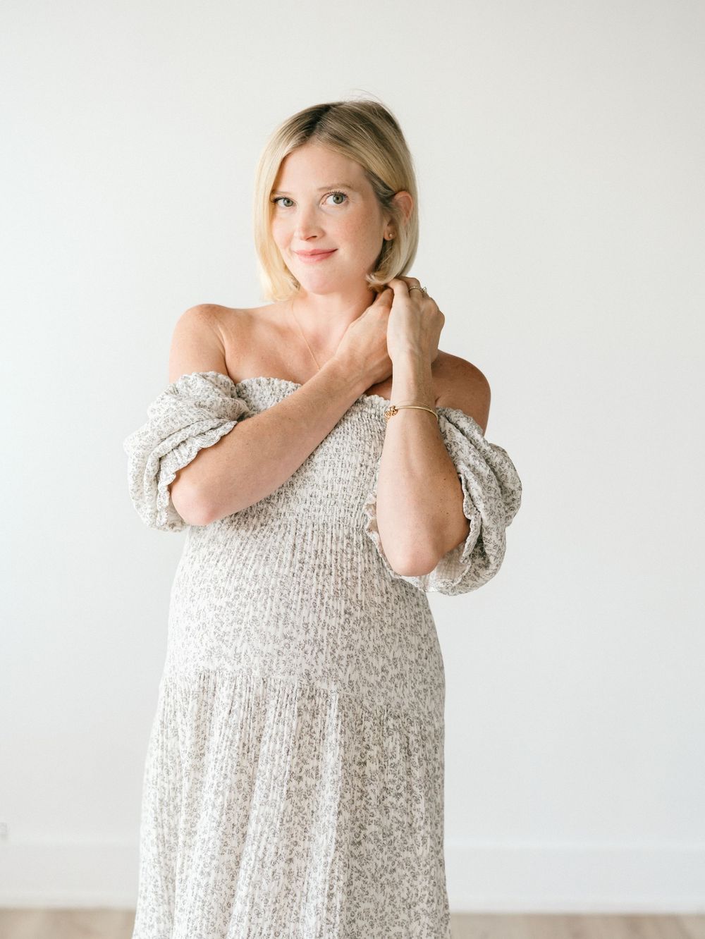 A maternity studio session with a mother playing with her blond hair.
