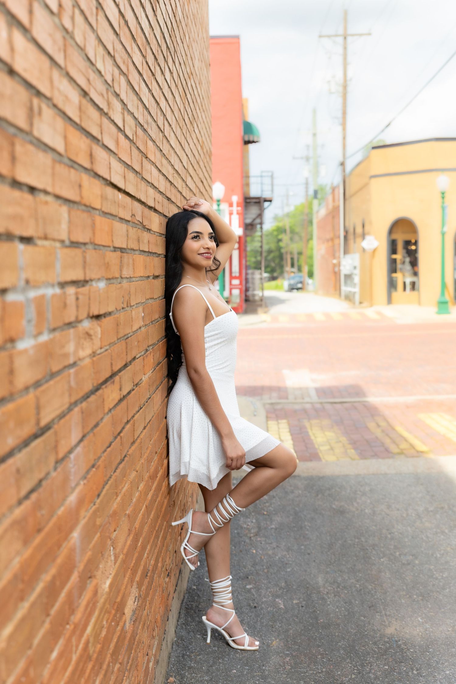 Studio portrait in peach dress against white backdrop.