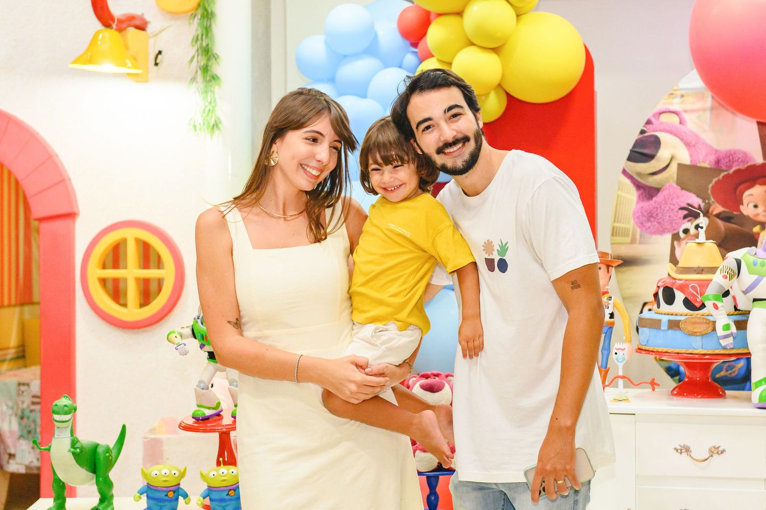 A colorful kids birthday party setting with balloons and decorations against a pink and white backdrop.