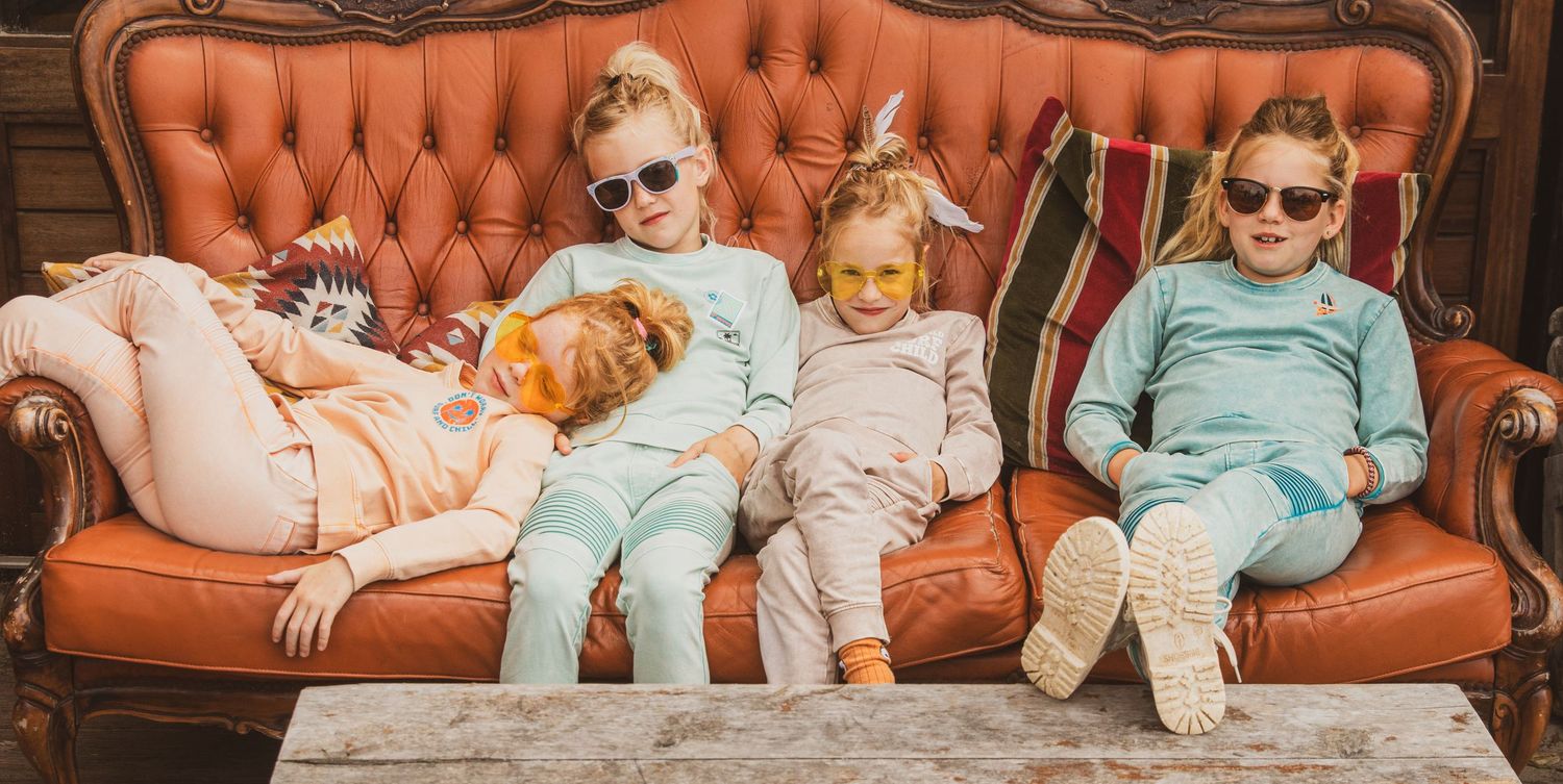 Group relaxing together on vintage orange tufted couch wearing matching loungewear.