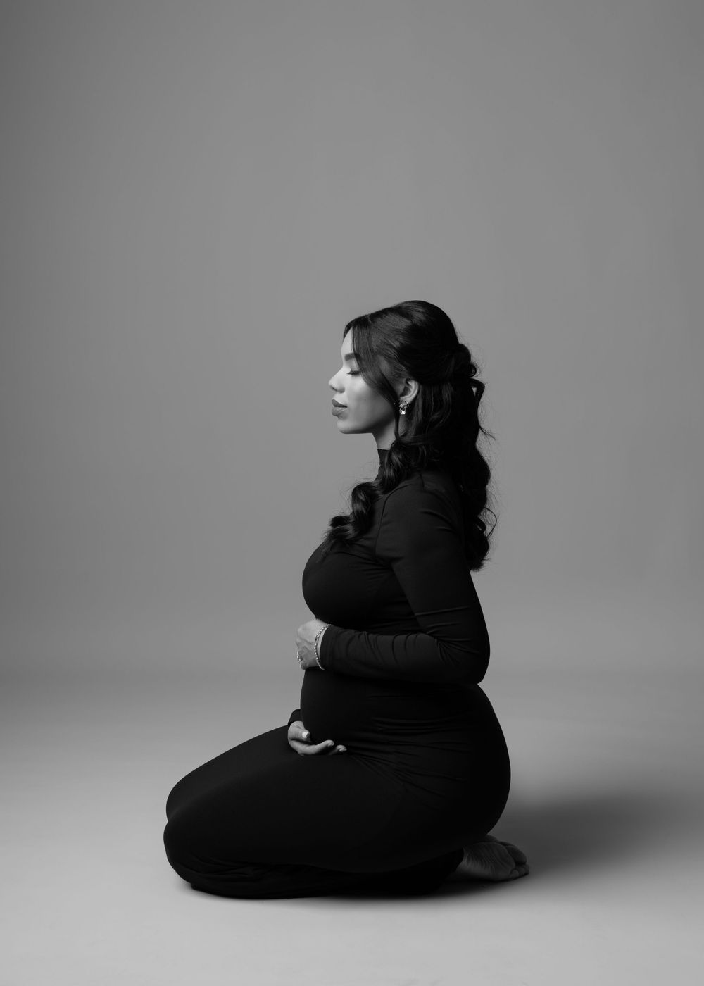 Black and white artistic portrait with dramatic side profile pose.