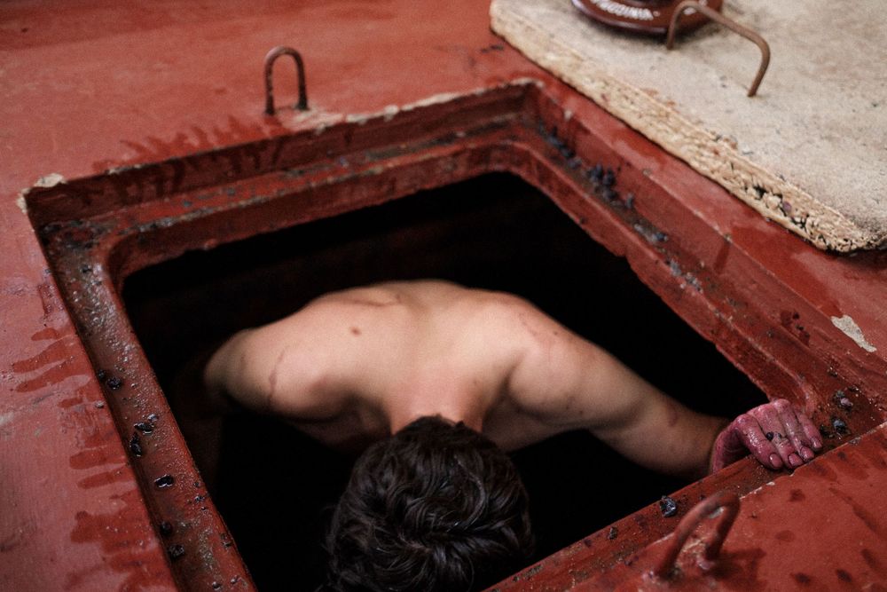 Wine fermentation process in traditional tank filled with red liquid.
