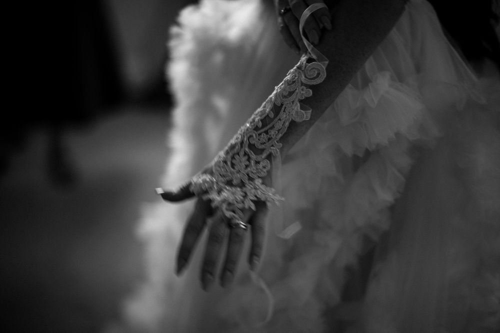 A close-up black and white shot of an intricate henna design on a hand with white fabric in the background at The Halifax Club