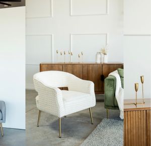 Contemporary studio setting with white loveseat and wooden accent furniture.