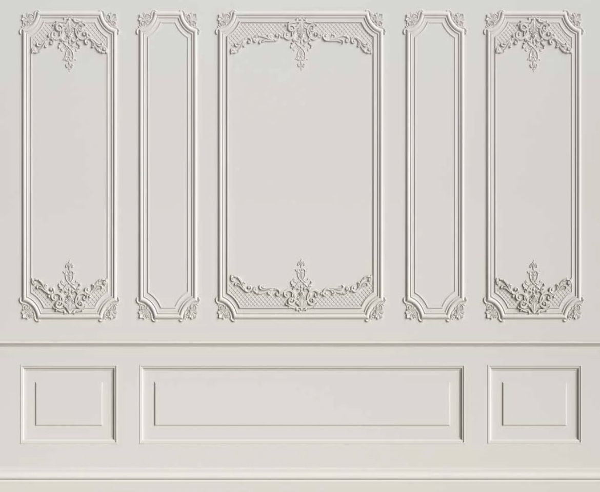 Classic white wall with ornate decorative molding panels and wainscoting.