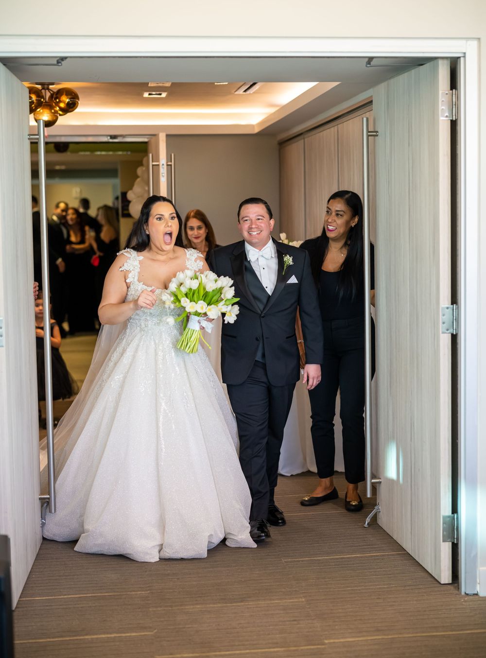 Wedding party entering venue through double doors.
