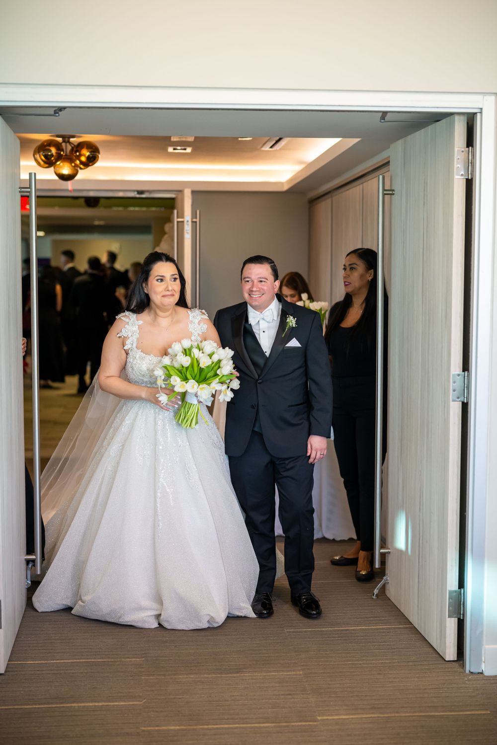 Wedding couple making entrance through double doors.