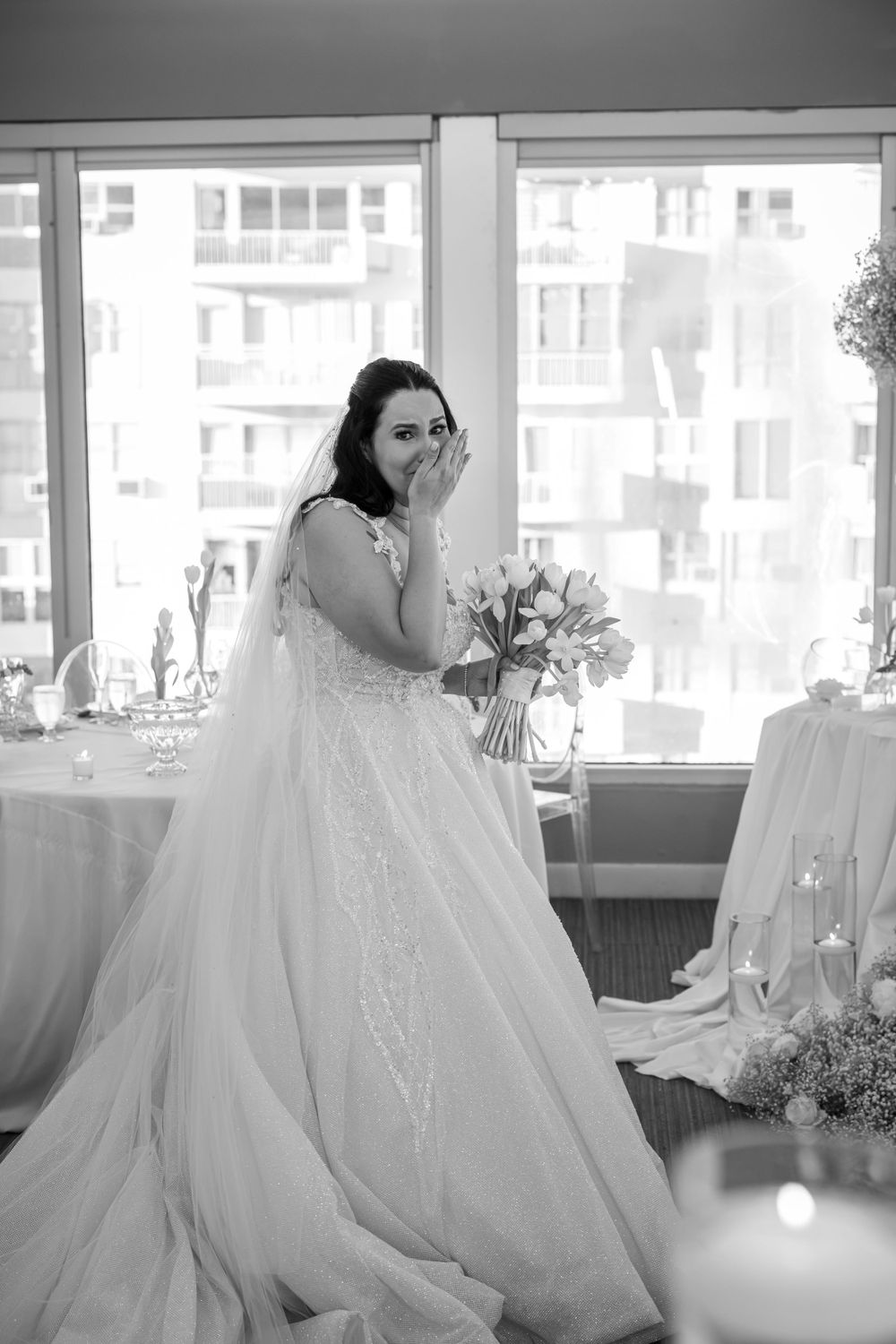 Emotional moment captured in black and white of bride in flowing gown.