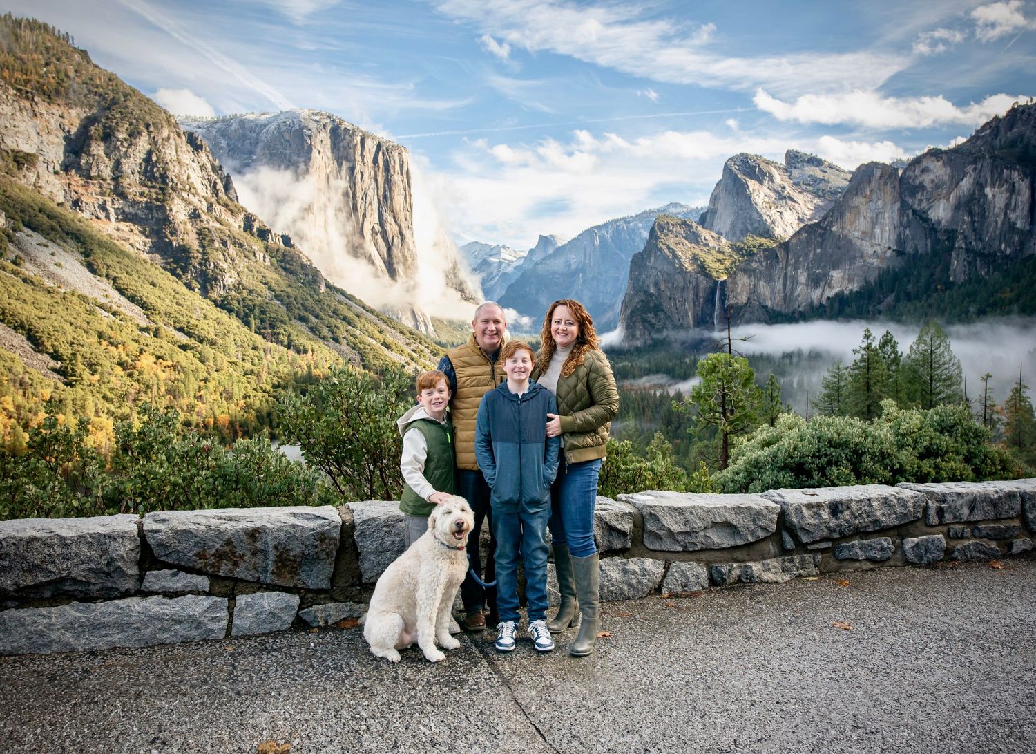 A fall family portrait with their dog at Tunnelview in Yosemite california