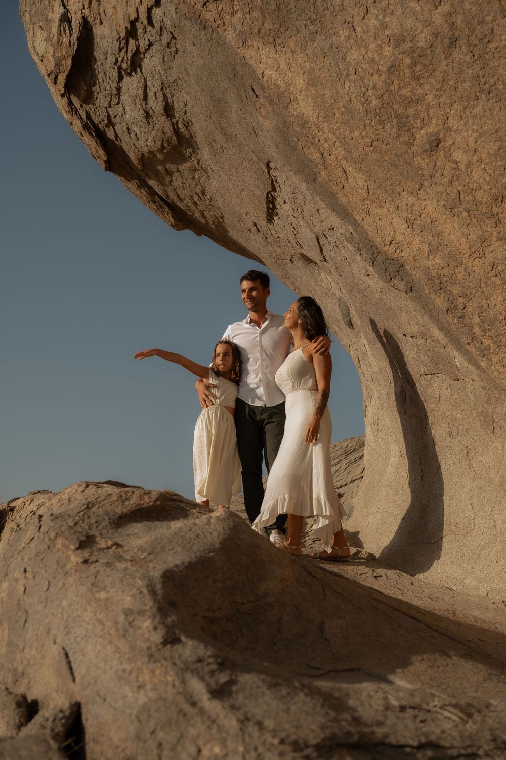 Couple exploring dramatic rock formations in desert landscape.