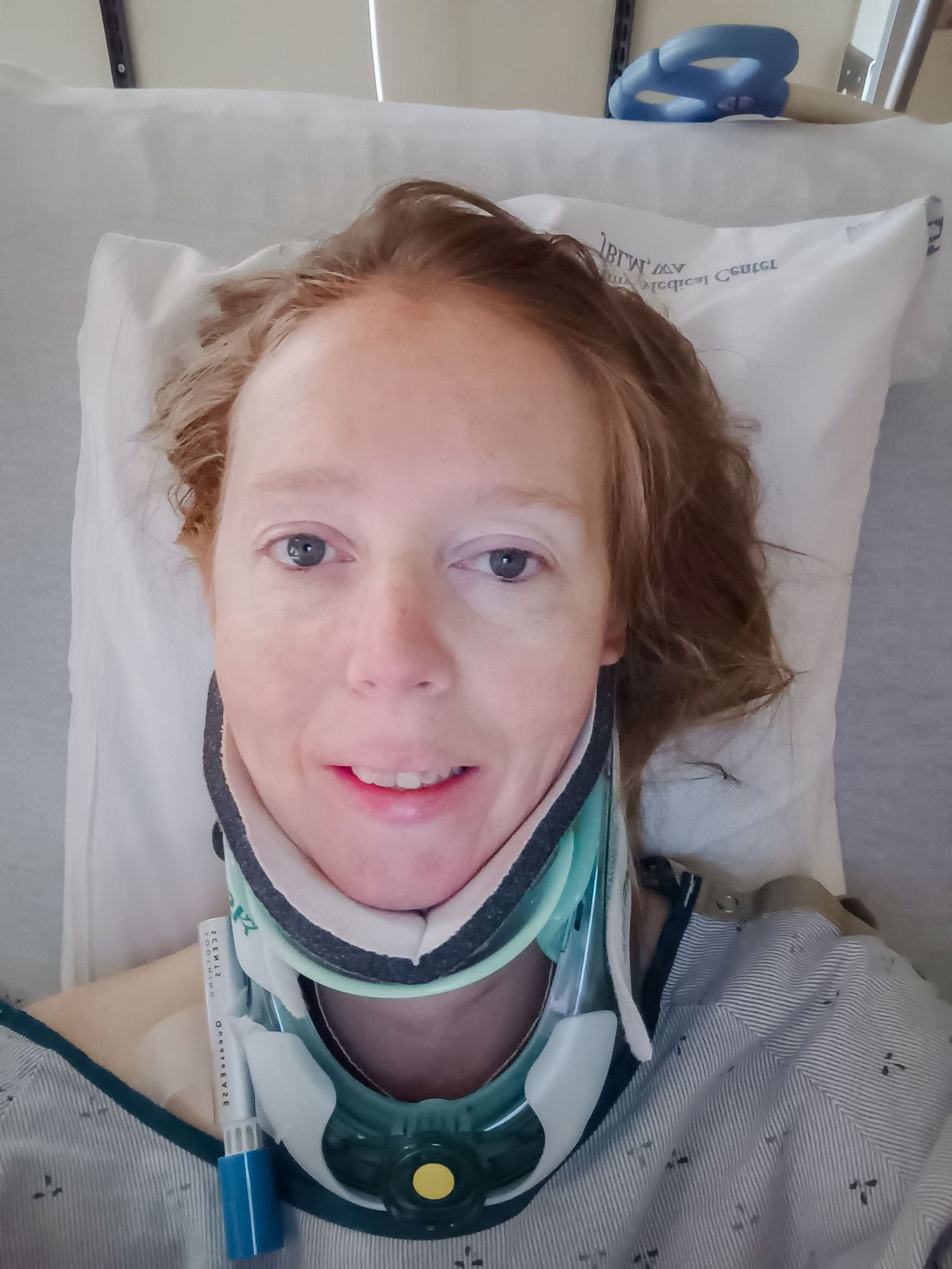 Hospital patient wearing a medical neck brace in bed.