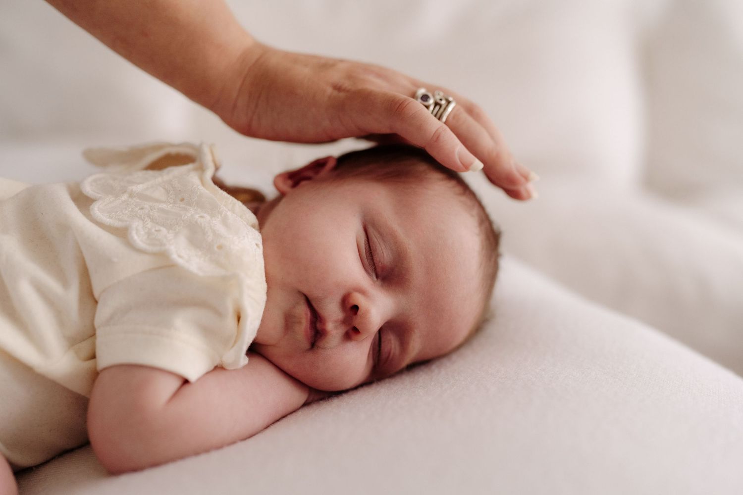 New mum patting baby during lifestyle newborn photography session