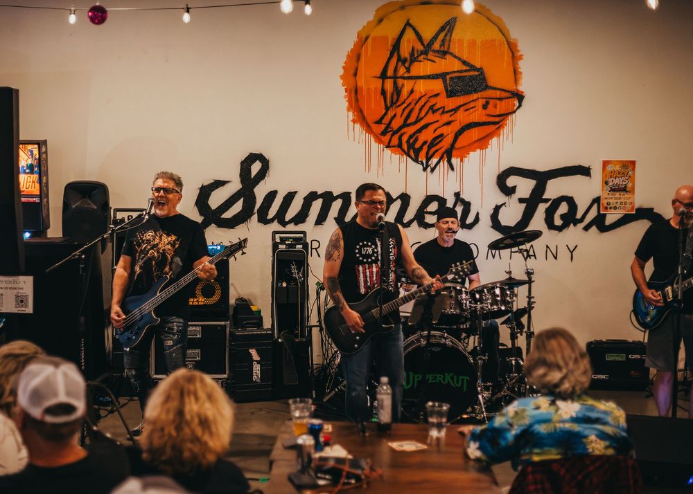 Rock band playing at a Summer Fox Clovis location in front of the Summer Fox logo
