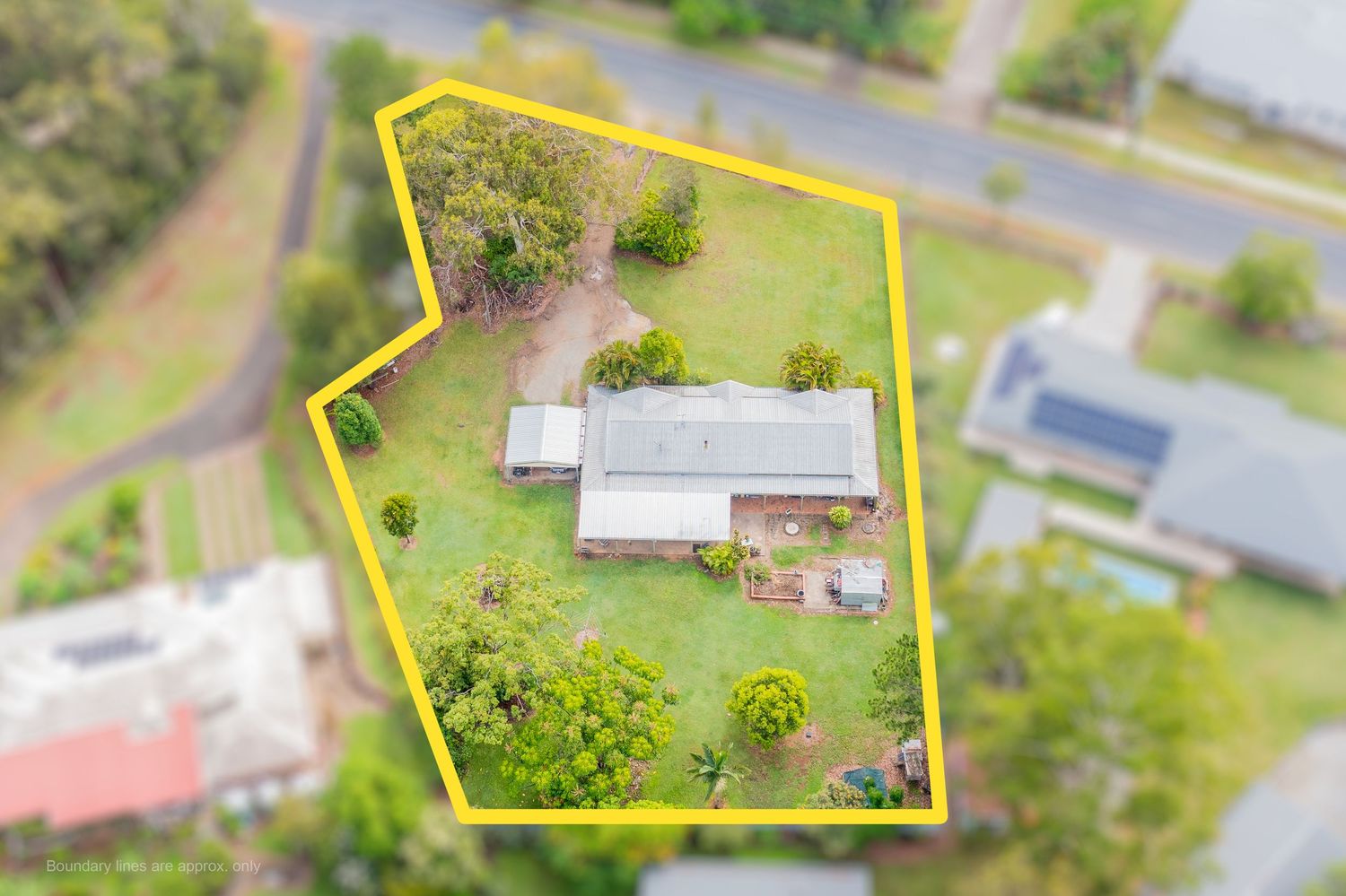 Aerial view of a single-story home on a large green block with property boundaries highlighted in yellow.
