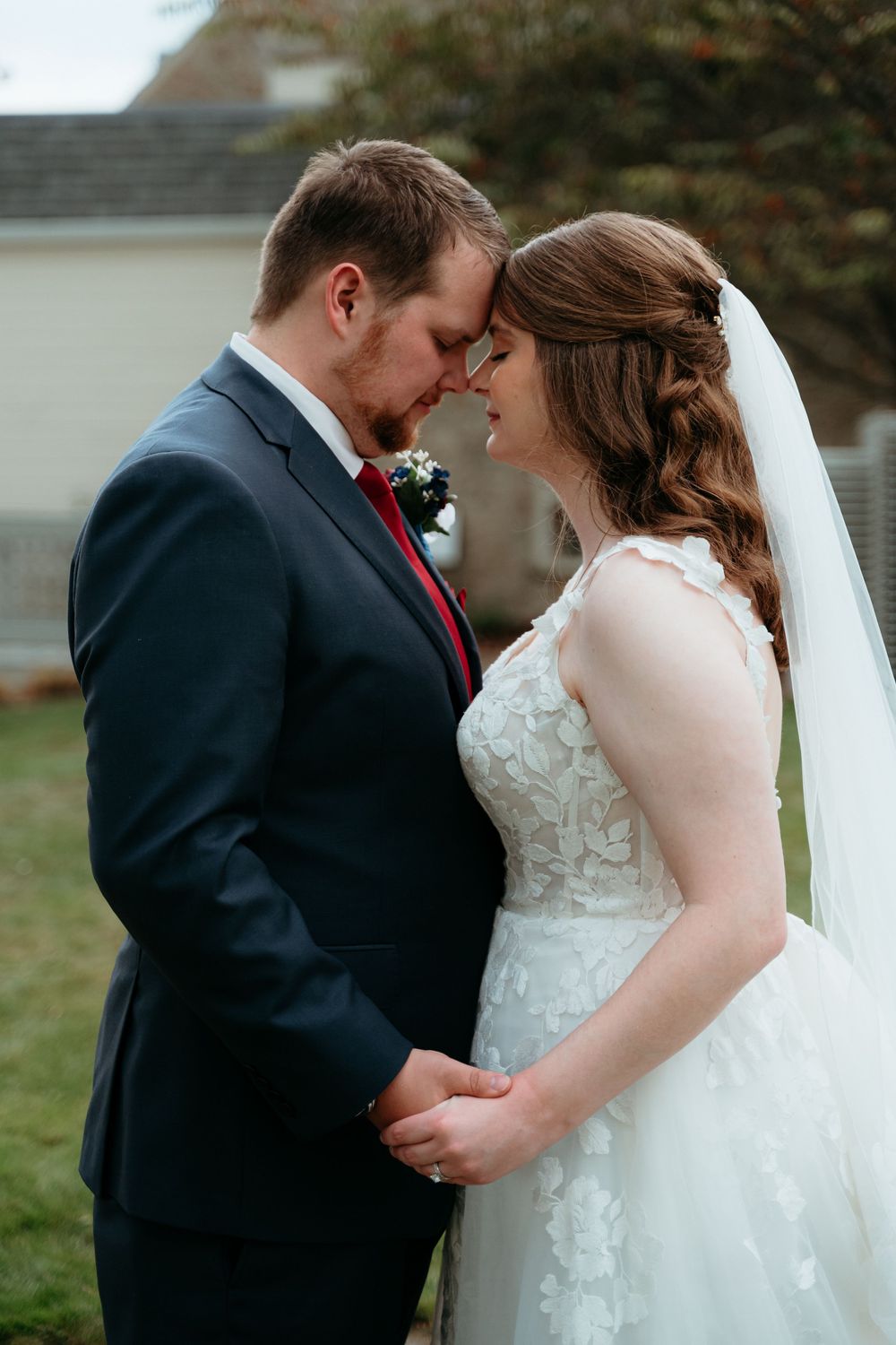 An intimate outdoor wedding portrait with soft natural lighting and autumn scenery. Bride and Groom embrace. Detroit Michigan wedding.