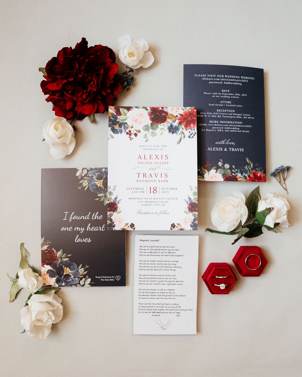 Wedding invitation suite with red and white flowers featuring elegant typography on gray cards.