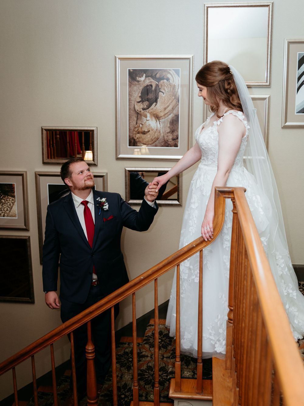 A wedding couple shares a tender moment on a wooden staircase indoors. Glen Oaks Golf Course, Farmington Hills Michigan.