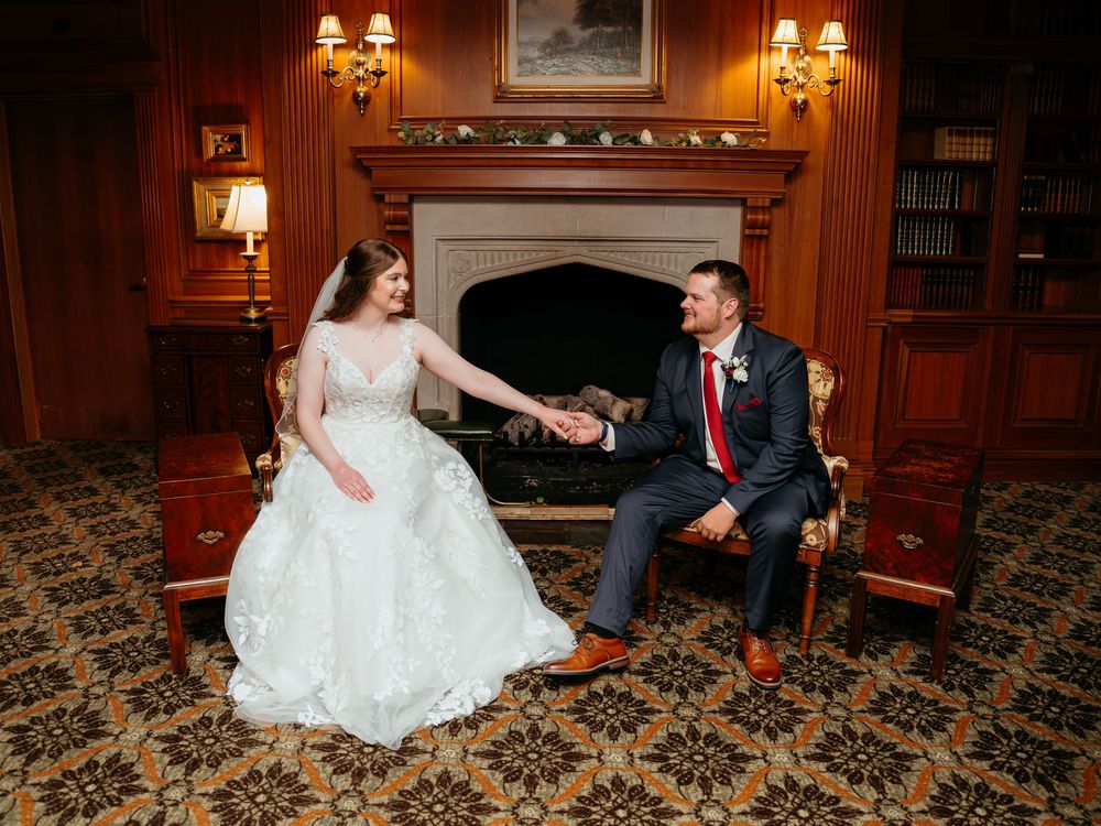 A romantic moment in an elegant wood-paneled room with vintage decor and lighting. Bride and Groom wedding photos. Glen Oaks golf course