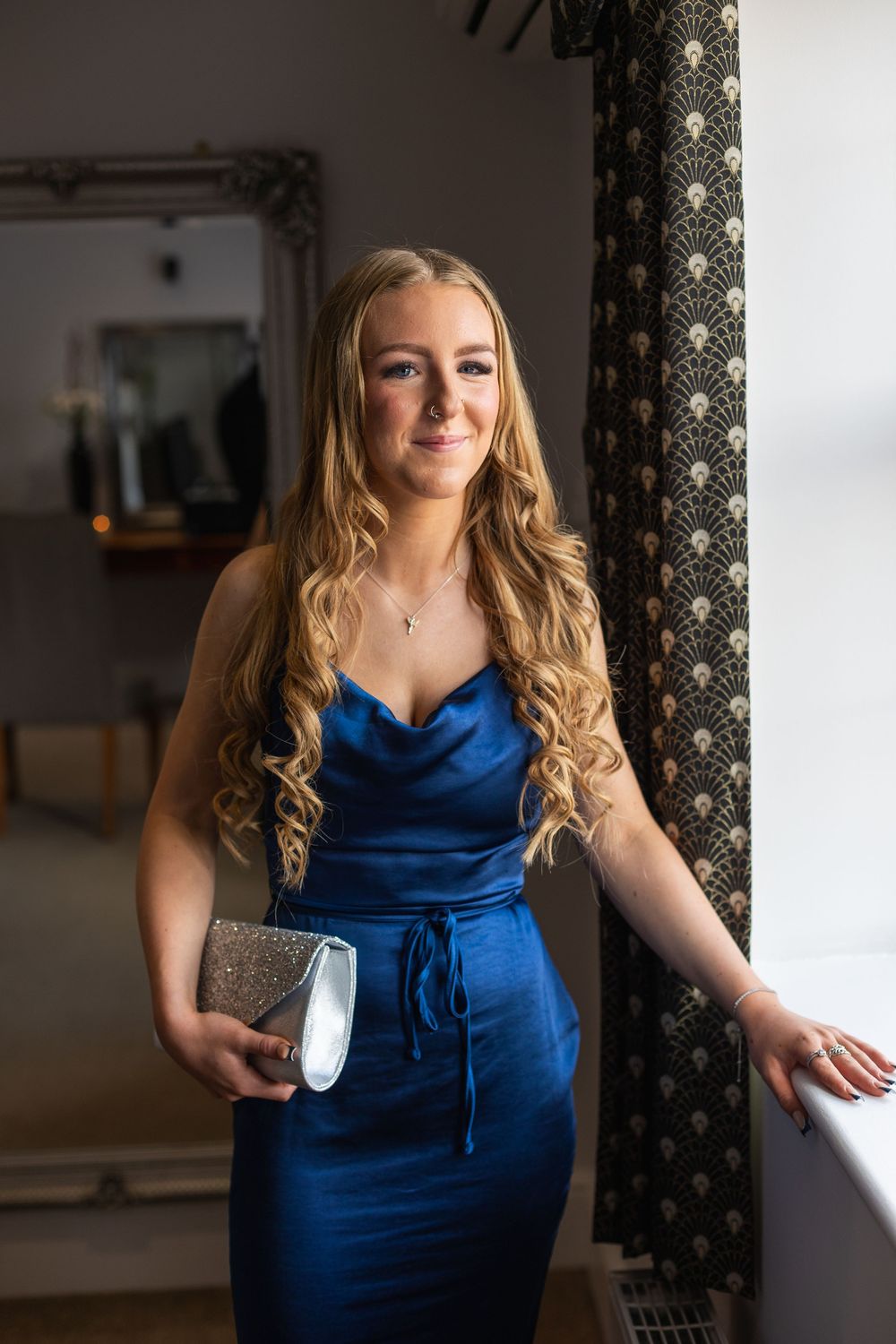 A series of photos showing a woman in a blue formal dress posing against a light interior background.