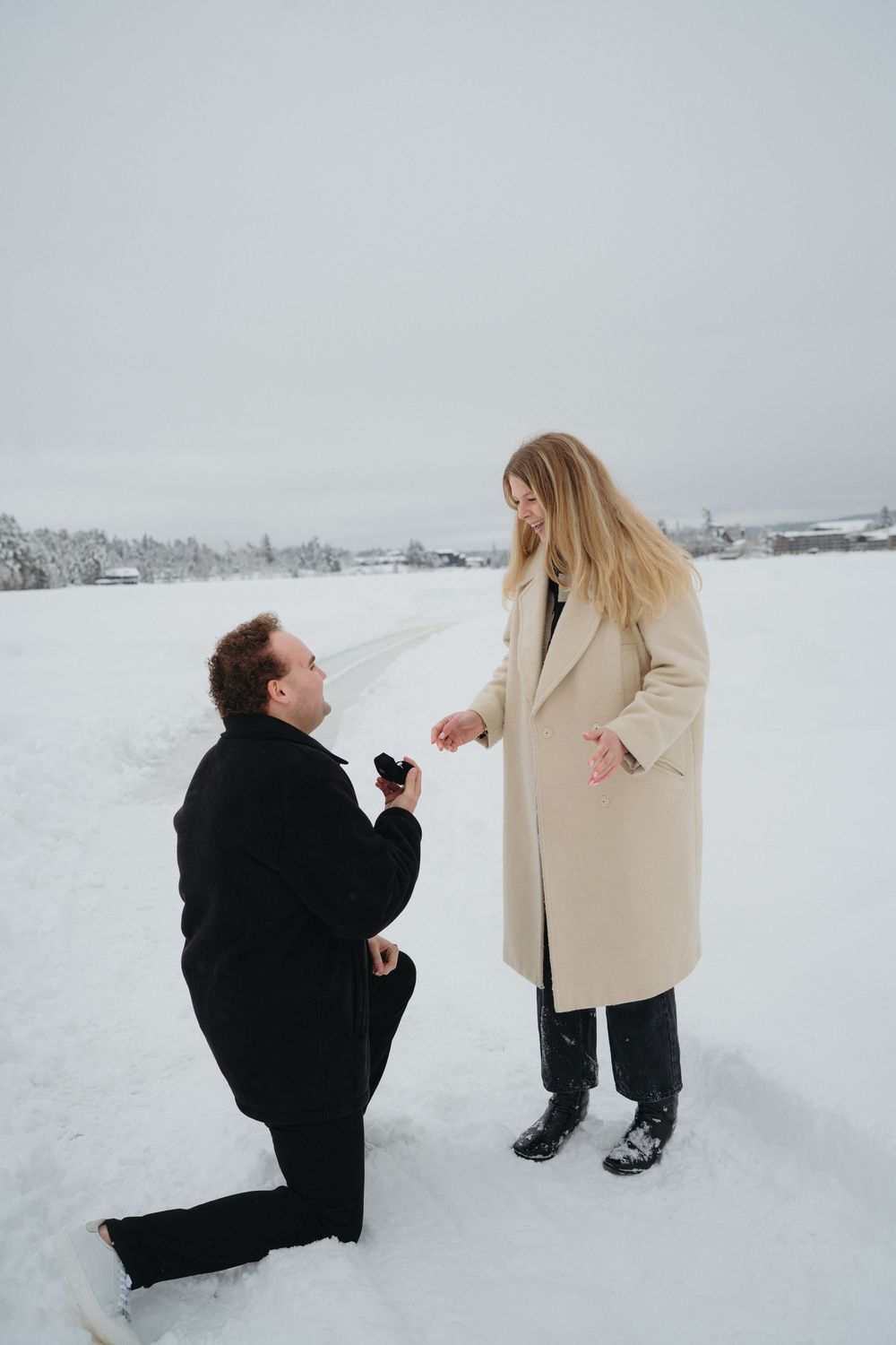 A romantic winter proposal scene unfolds as two people share a special moment in the snow-covered landscape.