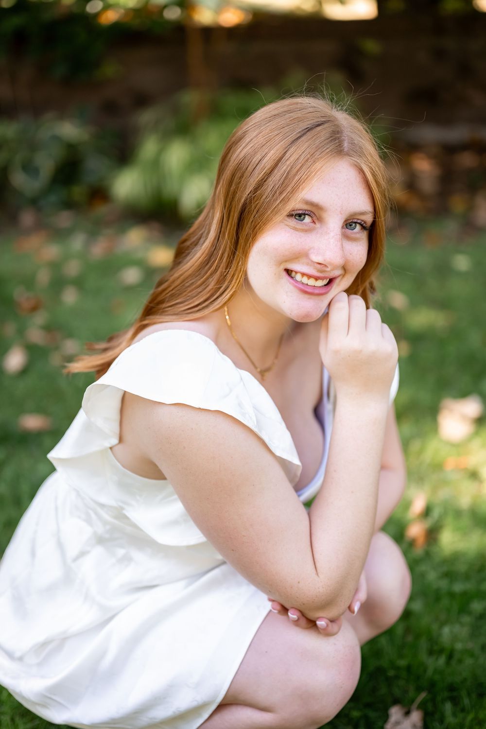 A series of outdoor portraits showing someone in a white sleeveless top sitting on grass in warm natural lighting.