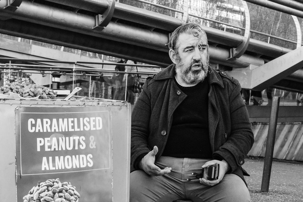Man selling peanuts and almonds on the streets in London - black and white image