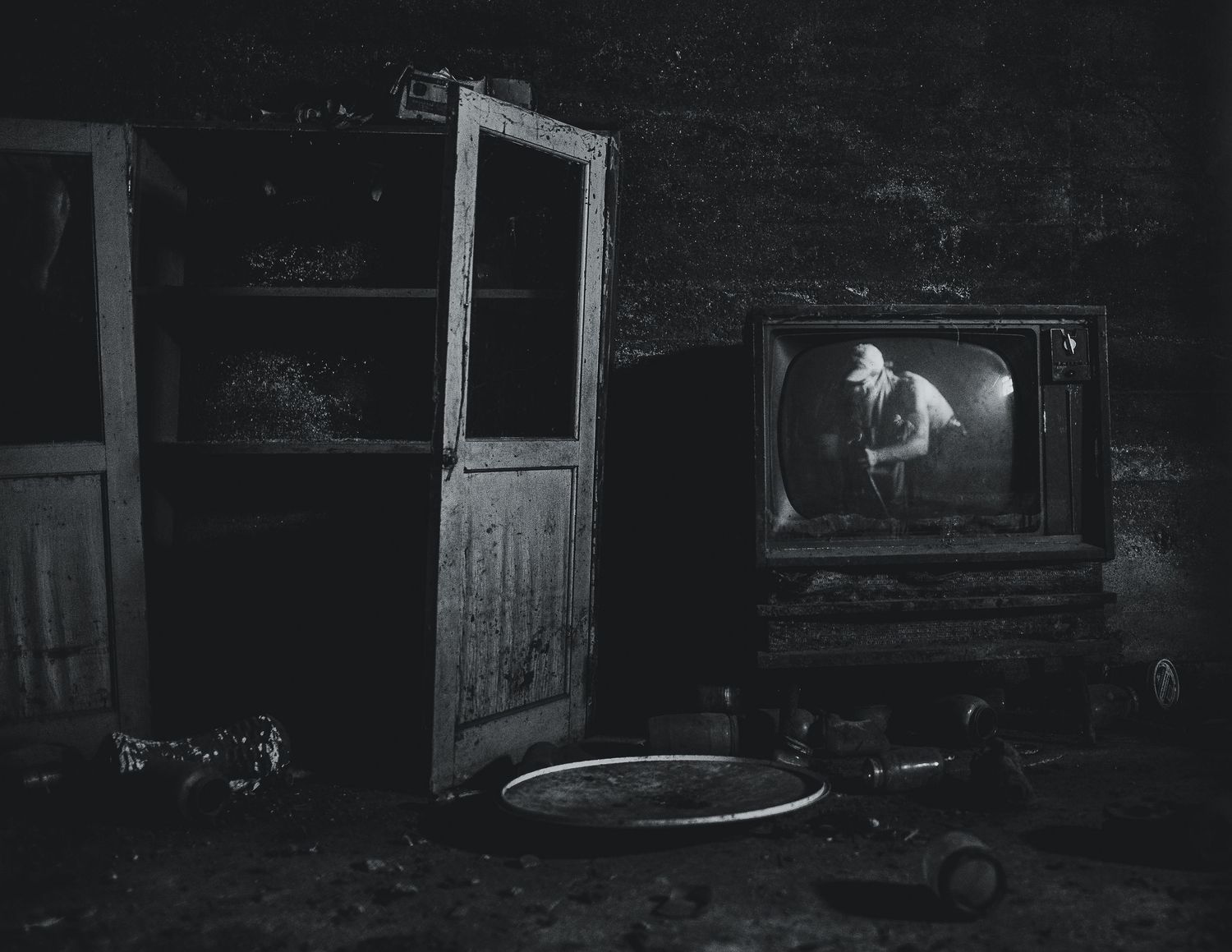 A black and white film noir style image shows a dark alleyway with dramatic lighting and shadows.